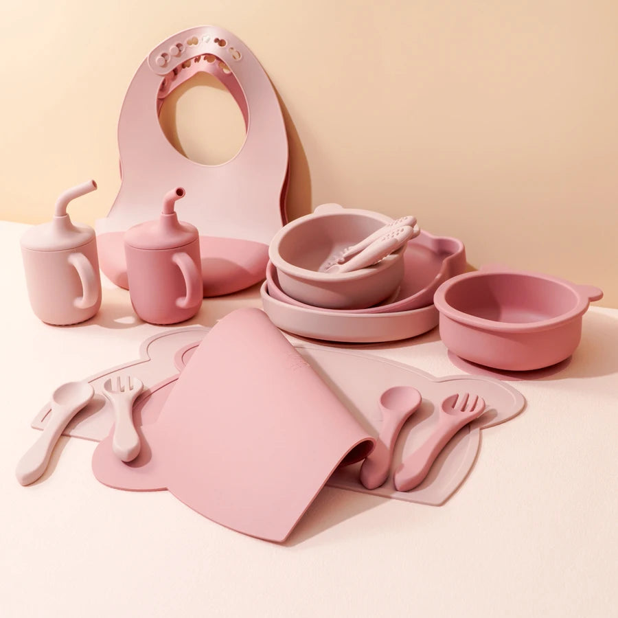 Pink children's tableware set on a light pink background